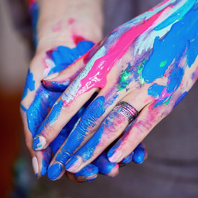 Hände mit blauer und pinker Farbe beschmiert